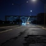 Rua noturna em Brasília com iluminação pública deficiente, expondo negligência histórica no DF.