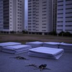 Documentos imobiliários com selos e calculadoras em escritório de Brasília, representando elevação de custos em transações no DF.