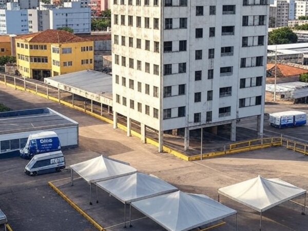 Rua em Taguatinga com hotel abandonado e barreiras para implosão, veículos de acolhimento do GDF ao fundo.