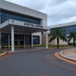 Fachada do Hospital Anchieta com fita de isolamento policial, representando investigação por mortes com doses excessivas de potássio.