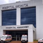 Fachada do Hospital Anchieta com fita de isolamento policial, representando escândalo de tentativa de homicídio.