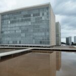 Edifício da CLDF em Brasília sob céu nublado, simbolizando lei que adiciona primeiros socorros como obstáculo em concursos do DF.