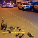 Cena de crime em rua de Taguatinga com viaturas policiais e fita de isolamento, sugerindo assassinato simulado como suicídio após bebedeira.