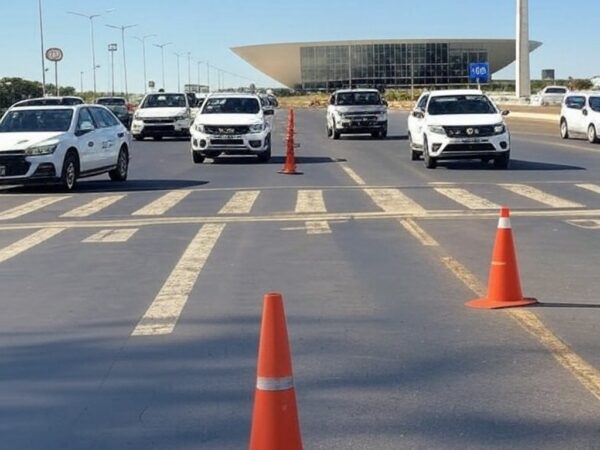 Viaturas do Detran-DF em ação educativa de trânsito em via de Brasília, com sinalizações e arquitetura local.