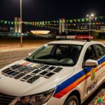 Viatura da PMDF em rua de Brasília com celulares furtados no Carnaval, confetes no chão e arquitetura moderna ao fundo.