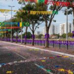 Rua em Brasília com confetes e máscaras de Carnaval espalhados, representando campanha contra assédio nos blocos.