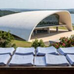 Mesa com pilhas de documentos burocráticos da Caesb em Brasília, representando burocracia excludente no DF.