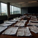 Documentos fiscais desorganizados em audiência na CLDF, representando desequilíbrios fiscais do GDF para 2025.