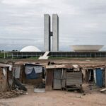 Prédio da CLDF em Brasília com bandeiras desbotadas, representando falhas na proteção a mulheres e idosos no Distrito Federal.