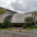 Edifício da Câmara Legislativa do DF em Brasília sob céu nublado, representando homenagem polêmica a corretores.