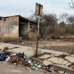 Rua deteriorada em Riacho Fundo I, DF, simbolizando 36 anos de abandono e melhorias tardias pelas autoridades.