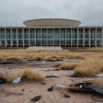 Edifício da CLDF em Brasília com área verde negligenciada, representando homenagem simbólica e críticas por ineficácia ambiental.