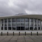 Sala de eventos da CLDF em Brasília com desorganização, papéis e cadeiras espalhados, ilustrando falhas na governança do DF.