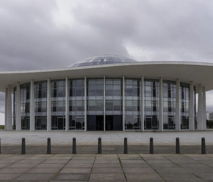 Sala de eventos da CLDF em Brasília com desorganização, papéis e cadeiras espalhados, ilustrando falhas na governança do DF.