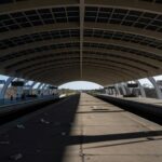 Estação de metrô em Brasília com plataformas vazias e trens parados, ilustrando ineficiências no Metrô-DF.