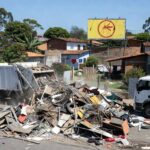 Remoção de 1,2 mil toneladas de entulhos no Riacho Fundo II para combater a dengue, com caminhões e pilhas de detritos em rua urbana.