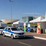 Ação educativa do Detran-DF em rua de Brasília, com viaturas e materiais sobre segurança no trânsito.