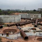 Obras de abastecimento de água em Brasília com paisagem seca ao fundo, destacando escassez hídrica no DF.