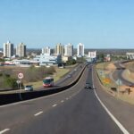 Rodovia BR-070 entre Taguatinga e Ceilândia no DF, com veículos e paisagem urbana, representando estudos para viadutos.